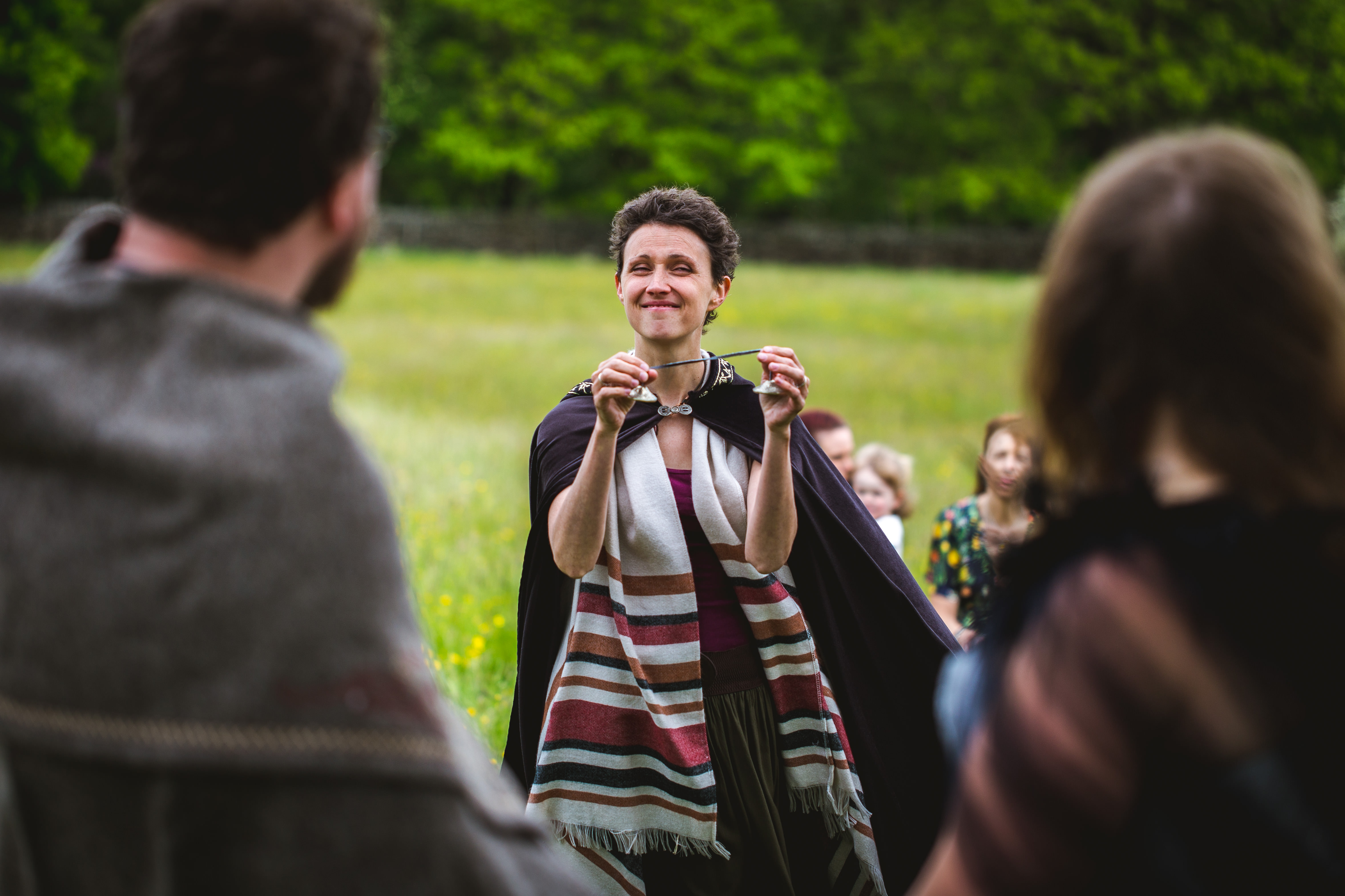 Celebrant Keli Tomlin smiles as she rings the sacred bells to clear the space before performing a pagan wedding ceremony